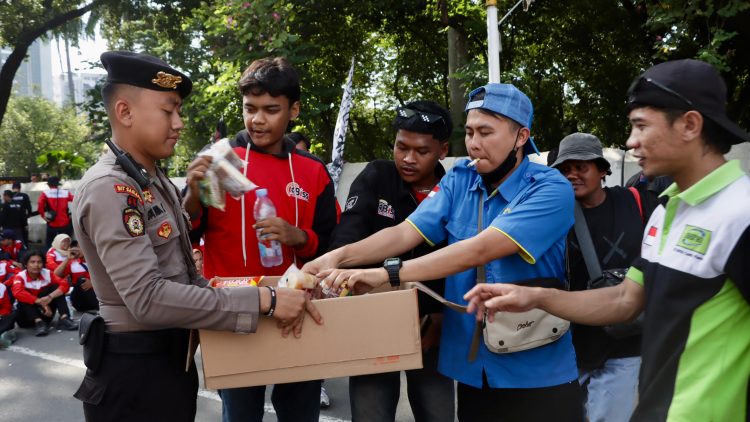 Di Tengah Terik Aksi, Petugas Kepolisian Turun Bagikan Air Mineral dan Roti ke Pengunjuk Rasa